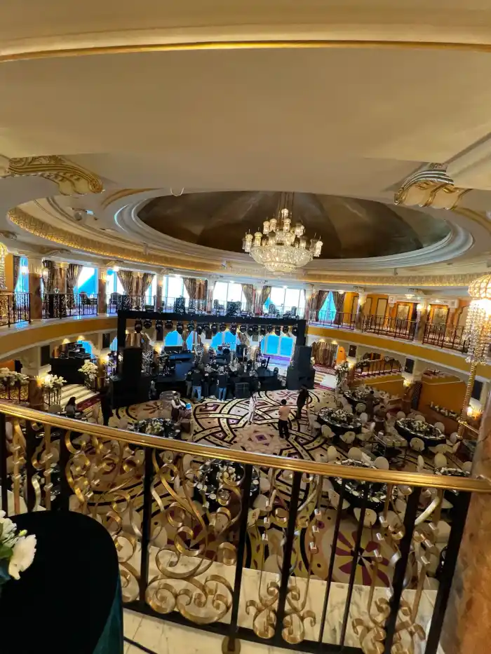 The same ballroom seen from the upper balcony, showing the stage, dance floor and set tables